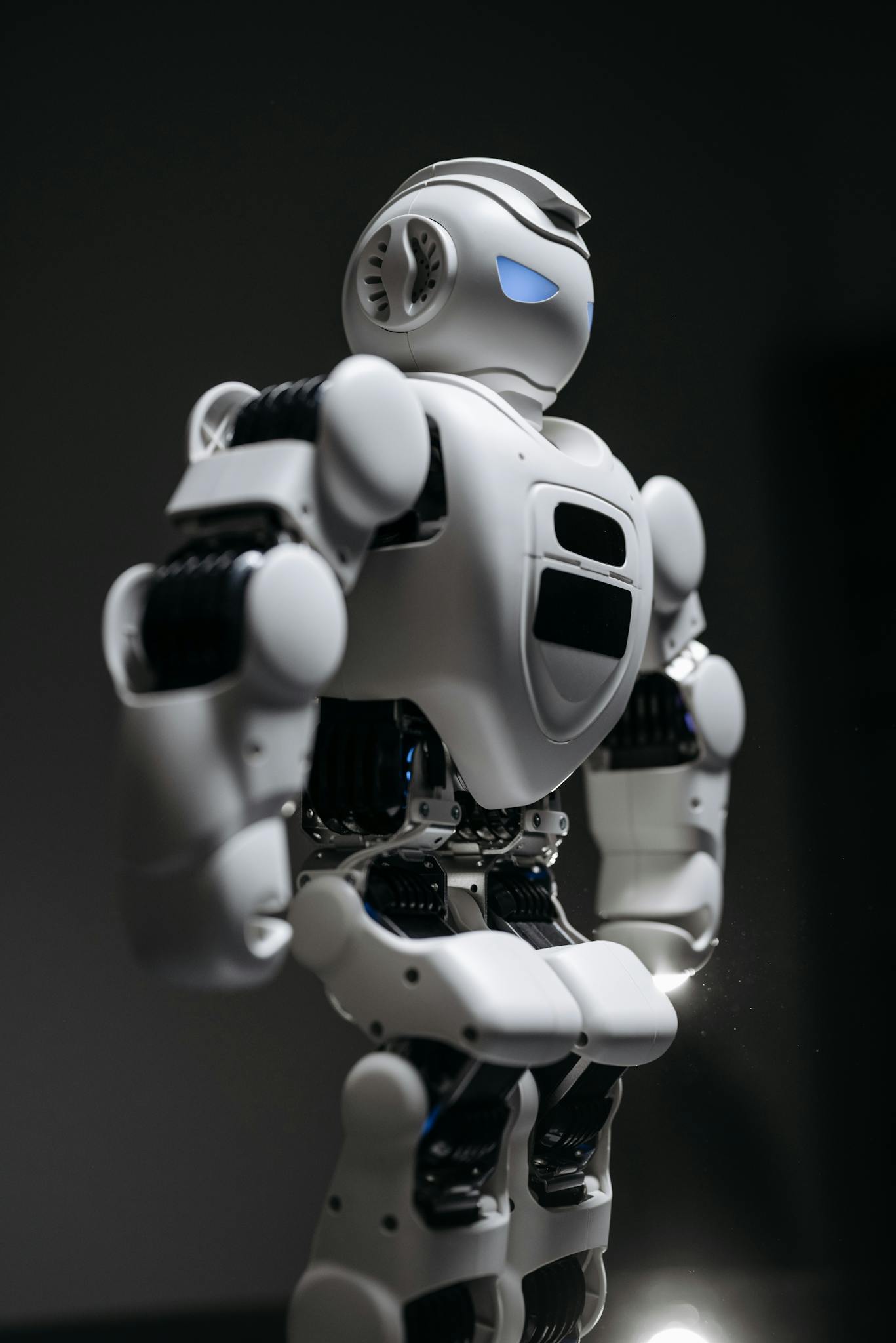 A detailed studio shot of a humanoid robot against a gray background, showcasing modern technology.